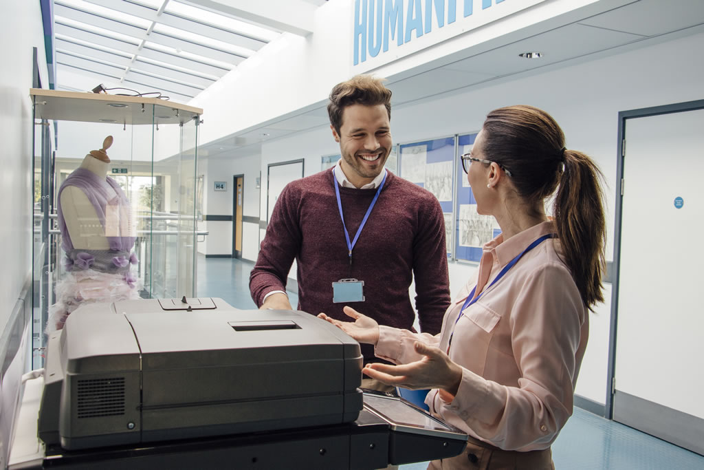 Teaching staff chatting at photocopier